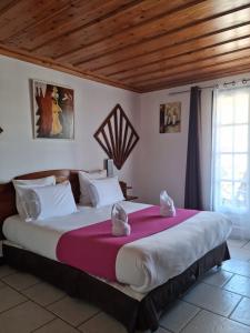 um quarto com uma cama grande num quarto em Hotel Des Neiges em Cilaos
