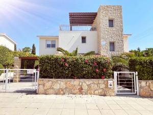 a house with a gate in front of a hedge at Villa14 Sea Breeze in Khlorakas