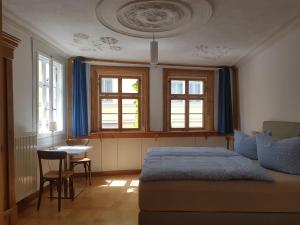 a bedroom with a bed and a table and windows at Ferienwohnung am Erfurter Dom in Erfurt