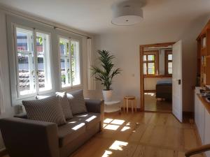 Una sala de estar con un sofá y algunas ventanas. en Ferienwohnung am Erfurter Dom, en Erfurt