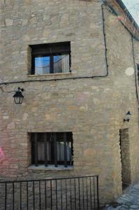 a stone building with two windows and a fence at Anina in Montsonis