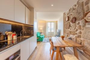 een keuken met een houten tafel en een stenen muur bij D&S - Lazaros Apartments in Porto