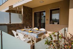 comedor con mesa y sillas blancas en Villa Le Mimose, en Pozzallo