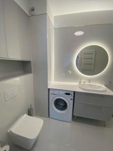 une salle de bains avec lave-linge et lavabo dans l'établissement Rezydencja Niechorze 108 Prestige by The Beach z Basenem i SPA, à Niechorze