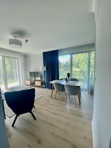 un salon avec une table et des chaises de salle à manger dans l'établissement Rezydencja Niechorze 108 Prestige by The Beach z Basenem i SPA, à Niechorze