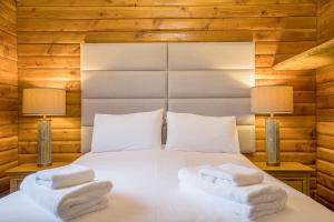 a bedroom with a white bed with two towels on it at Muir-lan cabin in Lochinver