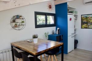 cocina con mesa de madera y nevera en Appartement sur les toits, très jolie vue Provence, en Gréoux-les-Bains