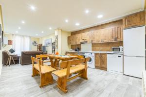 una cocina con una mesa y un refrigerador en APARTAMENTOS DELUXE COLLARUBIO en Cercedilla, en Cercedilla