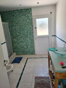 baño con lavabo y aseo y ventana en Tandil Casa Quinta en Tandil