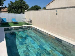 a swimming pool with two chairs and a table at Villa Jasmin in Carpentras