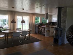 a kitchen and living room with a table and chairs at Rymlig villa med närhet till Tylösand och Halmstad GK in Halmstad