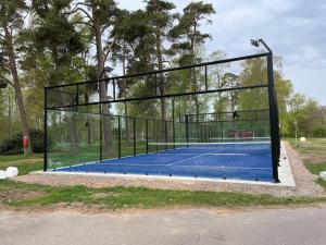 een tennisbaan met een hek op een tennisbaan bij Rymlig villa med närhet till Tylösand och Halmstad GK in Halmstad