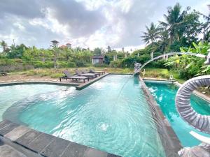 a pool with a water slide in a resort at Ubud Rice Field House in Ubud