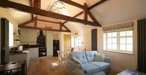 uma sala de estar com um sofá e uma cozinha em Beautiful 2 bed cottage picturesque tranquil setting em Sywell