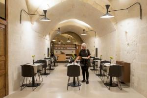 a woman standing in a room with tables and chairs at PIANELLE RESORT in Matera