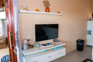 a living room with a tv on a wall at Beira-mar Chalé Maceió - Camocim in Maceio