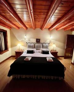 a bedroom with a large bed and wooden ceilings at Trawen Hostal Boutique in Caviahue