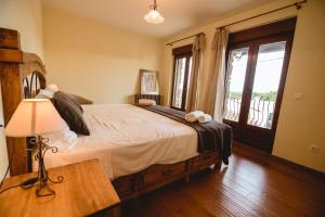 um quarto com uma cama com um candeeiro e uma janela em La pata del buey em Navamorisca