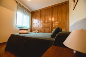 a bedroom with a bed with a wooden wall at La pata del buey in Navamorisca +5 photos