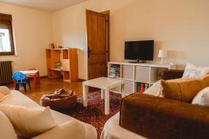 a living room with a couch and a tv at La pata del buey in Navamorisca