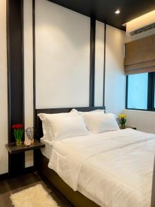 ein Schlafzimmer mit einem großen weißen Bett und einem Fenster in der Unterkunft Aurora Vista Homestay Bangi at Vista Bangi With WIFI NETFLIX GYM SAUNA COWAY SWIMMING POOL-RIVER VIEW in Kajang