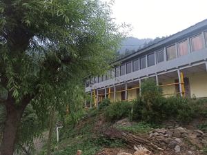 JibhiにあるMidway Home stayの木の横の丘の上の建物