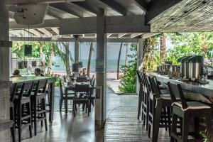 a restaurant with tables and chairs and a view of the ocean at DePraiaBrasil in Icaraí