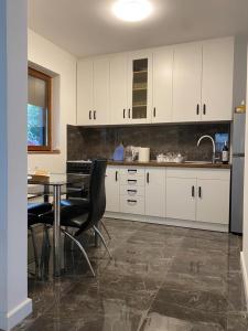 a kitchen with white cabinets and a table and chairs at House Reko in Novi Grad