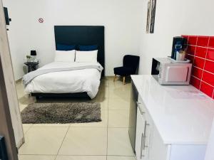 a bedroom with a bed with a black headboard at Zindiza Guesthouse in Witbank