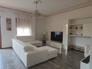 a white living room with a white couch and a tv at Spazioso appartamento in centro Città in San Benedetto del Tronto