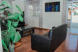 a living room with a black chair and a plant at Hotel Santa Maria in Arua