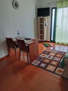 Apartamento Valados في بونتا ديلغادا: غرفة معيشة مع طاولة وكراسي وثلاجة