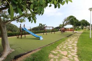 a playground with a blue slide in a park at TAMARINDO in Denia