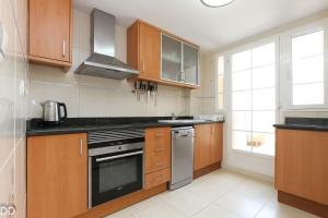 a kitchen with wooden cabinets and a stove top oven at TAMARINDO in Denia
