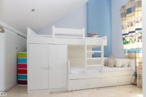 a white bunk bed in a childs room at TAMARINDO in Denia +14 photos