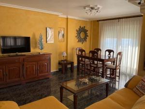 sala de estar con TV, mesa y sillas en BRISA DE PONIENTE, con cochera y a. acondicionado, en Águilas