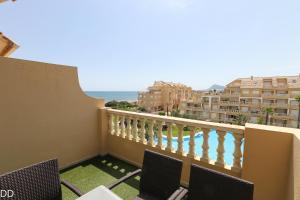 a balcony with chairs and a view of the ocean at TAMARINDO in Denia
