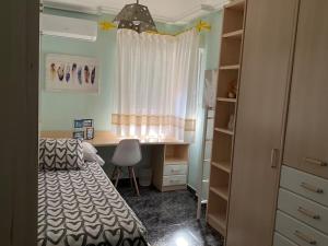 a bedroom with a bed and a desk and a window at BRISA DE PONIENTE con cochera y aire acondicionado in Águilas