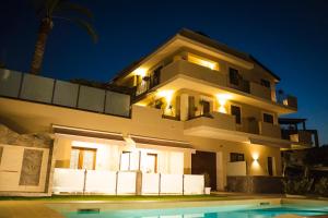 a large white house with a pool in front of it at Villa Le Mimose in Pozzallo