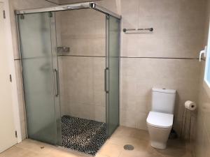 a bathroom with a glass shower with a toilet at Acogedora casa en Cap Negret, ubicada a primera línea de la playa. in Altea