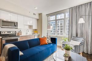 a living room with a blue couch and a kitchen at Sentral Union Station in Denver