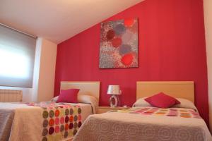 Balcondel Turia في Villastar: سريرين في غرفة بجدران حمراء