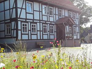 un edificio blanco y negro con flores delante en Landhaus Weserbergland - Anton, en Vahlbruch