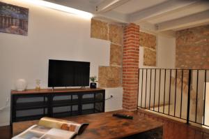 Una sala de estar con un televisor de pantalla plana en una pared. en Liolà's Home, en Noto