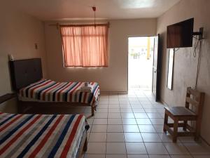 Habitación con 2 camas, mesa y silla en HOTEL MARIA TERESA en Río Verde