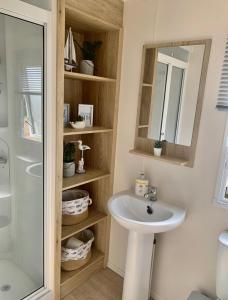 a bathroom with a sink and a mirror and a shower at The Wardens Escape - Tattershall Lakes Country Park in Tattershall