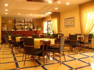 a restaurant with tables and chairs and a bar at Hotel Albatros in Terracina