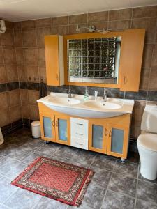 a bathroom with two sinks and a toilet and a mirror at Mysig fjällstuga med direktanslutning till fjället in Oviken