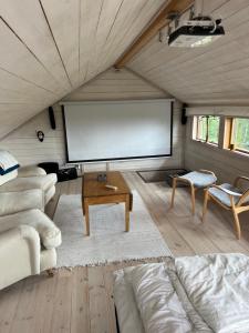 a living room with a large screen in a house at Mysig fjällstuga med direktanslutning till fjället in Oviken