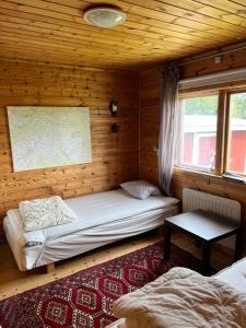 a bedroom with two beds in a wooden cabin at Mysig fjällstuga med direktanslutning till fjället in Oviken